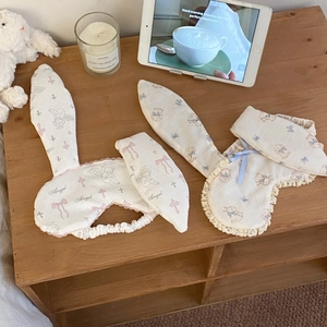 Detail of cute rabbit ear sleep masks with lace edges and cartoon prints on wood