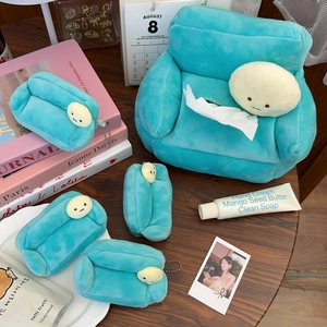 Close-up of light blue plush sofa tissue box with matching cartoon charms on wood