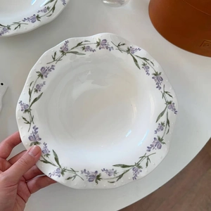 Detailed close-up of wavy French vintage ceramic plate with purple lavender floral patterns