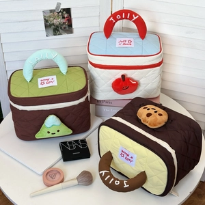 Quilted cosmetic bag detail showing Jolly handles and cute plush 3D fruit patches