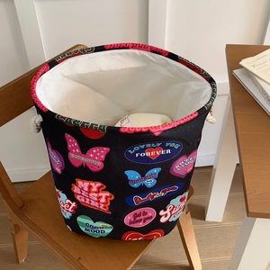 Collapsible vintage heart print laundry basket with rope handles on a wooden chair