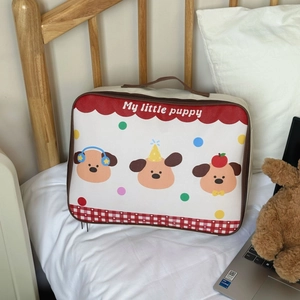 Detail of cute cartoon puppy travel bag on a cozy bed with plush bear accessory