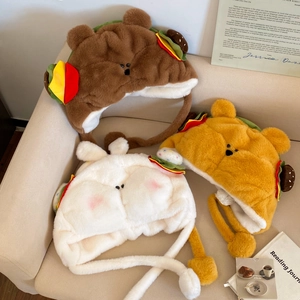Trois bonnets en peluche créatifs avec ours burger et lapin sur un canapé doux