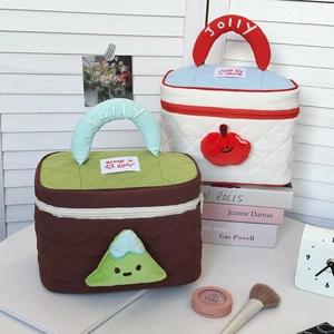 Detail of quilted cosmetic bags with cartoon handles and Jolly embroidery in a lifestyle setting