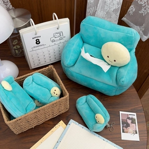 Detail of plush green sofa tissue box cover and cute matching charm on a wooden table