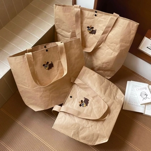 Detailed close-up of cartoon puppy embroidery on brown paper-style tote bag set
