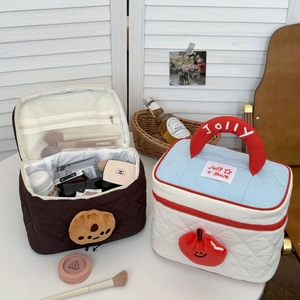 Quilted cosmetic bags with cartoon charms and internal mesh pockets for makeup storage
