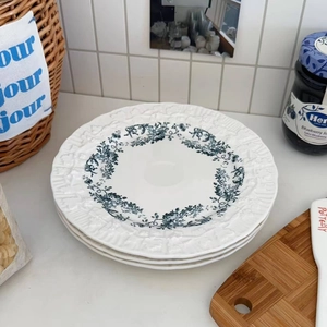 Close-up of vintage blue floral patterns and embossed edges on ceramic dessert plates