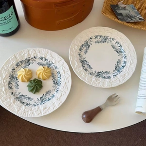 Close-up of French floral ceramic plate with blue flower patterns and embossed wavy edges