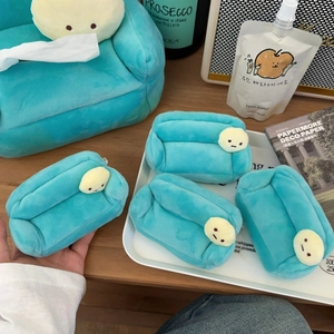 Detail of cute green plush sofa tissue box and mini pouch on a wooden desk setup