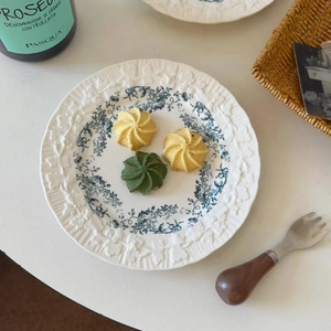 Macro view of French floral ceramic plate featuring blue patterns and relief details