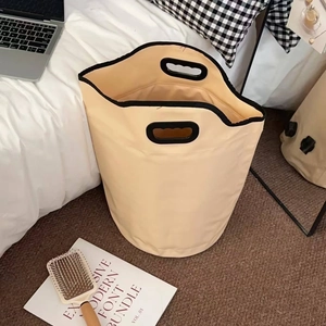 Portable beige folding foot bath bucket with durable handles in a cozy home setting