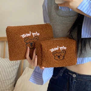 Detail of soft teddy fleece makeup bags featuring cute brown bear embroidery with zippers