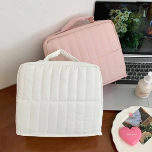 Vertical quilted makeup bags in pink and white with handle and zipper closure details
