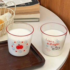 Set of two cute cartoon dog glass cups with red rims in a cozy home breakfast setting