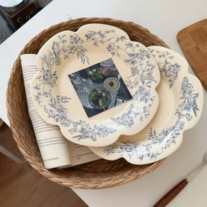 Close-up of vintage ceramic plate with blue floral patterns and scalloped edges