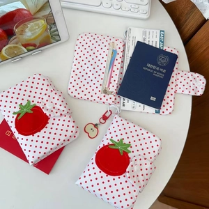 Détail du porte-passeport à pois avec broderie de tomate et fentes pour cartes