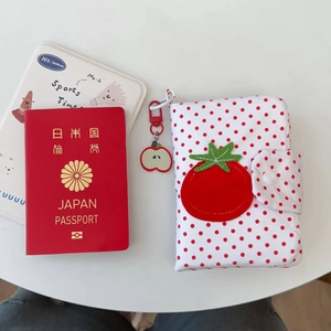 Détail de la broderie tomate sur un protège-passeport de voyage à pois rouges