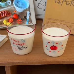 Close-up of heat-resistant glass cup featuring red rim and cute cartoon puppy illustration