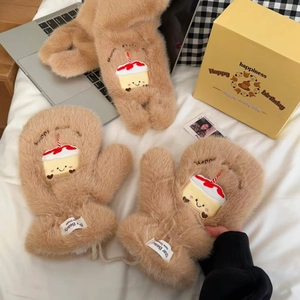 Detail of plush brown mittens with embroidered birthday cake patch and soft texture
