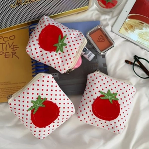 Vue à plat de mini pochettes tomates à pois avec fermeture éclair pour accessoires