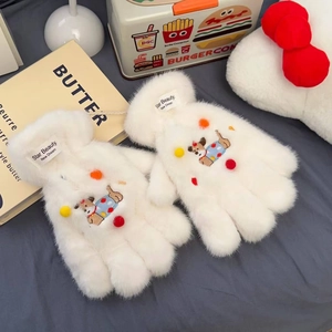 Detail of white plush gloves featuring bear embroidery and colorful pom-poms
