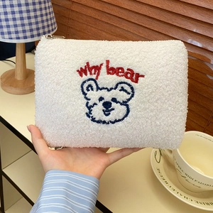 Detail of white sherpa makeup bag with Why Bear embroidery and metal zipper closure