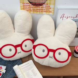 Detailed view of white plush rabbit warm water bag with red glasses and soft fluffy texture