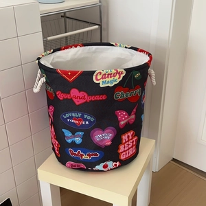 Detail of fabric laundry basket with colorful retro prints and cotton rope handles