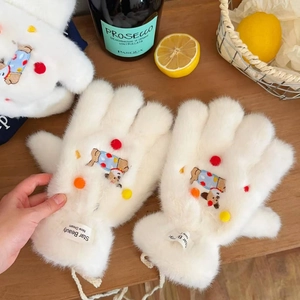 Detailed view of white plush gloves featuring cute bear embroidery and colorful pom-poms