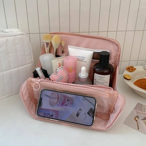 Detail view of pink travel toiletry bag with interior brush slots and phone pocket
