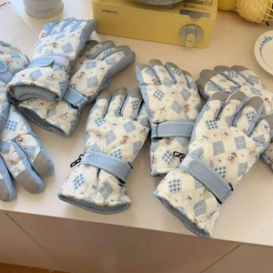 Detail of waterproof ski gloves featuring blue plaid, bear print and anti-slip palms