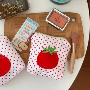 Détail du porte-monnaie tomate à pois rouges pour rouges à lèvres sur plateau bois