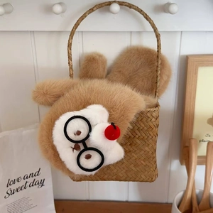 Detail of cute cartoon cat plush charm with round glasses on a woven basket bag