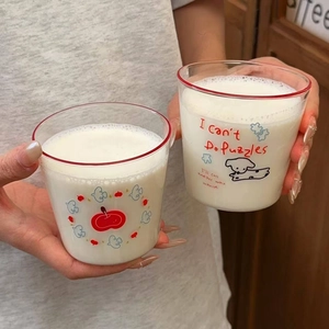 Detail of transparent glass cups with red rims, featuring cute puppy and apple illustrations