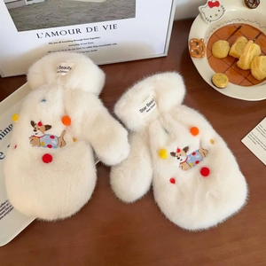 Close-up of white plush dachshund gloves with cute dog embroidery and pom-pom details