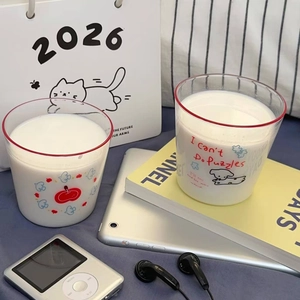 Detail of cartoon puppy and apple prints on heat-resistant glass milk cups with red rim
