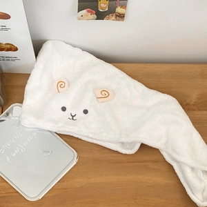 Detail of soft white coral fleece hair towel with cute sheep design and secure button