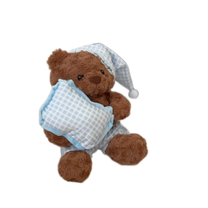 Cute brown teddy bear plush in blue plaid pajamas and nightcap for kids sleep