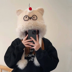 Détail du bonnet en tricot beige avec cerises et broderie de lunettes décoratives