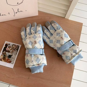 Detail of light blue winter ski gloves with adjustable wrist strap and rib knit cuff