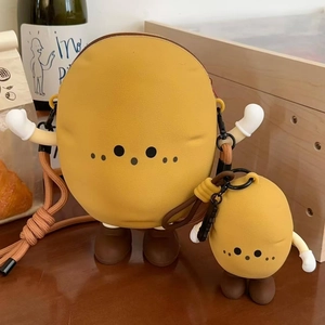 Close-up of cute potato silicone shoulder bag and mini coin purse set on wooden table