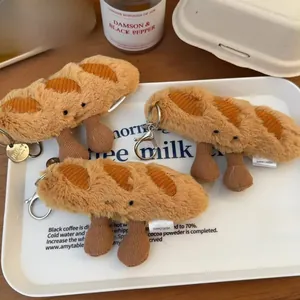 Macro detail of plush baguette keychain with signature JELLYCAT tag on white tray