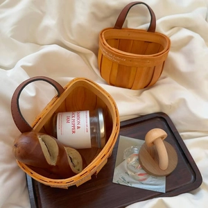 Nordic woven wood basket with leather handles for kitchen storage in a French rustic style