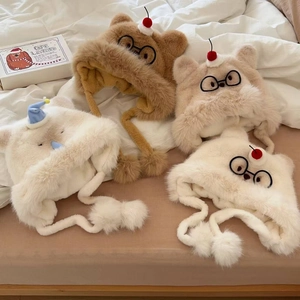 Détail de bonnets à oreilles en peluche épaisse avec décor cerise et broderie de lunettes