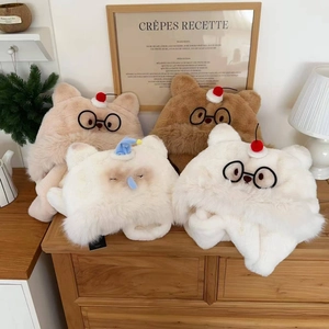 Dettaglio di cappelli di peluche a forma di gatto e orso con occhiali e ciliegie rosse