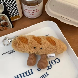 Macro detail of plush baguette keychain with soft texture and metallic silver spring clasp