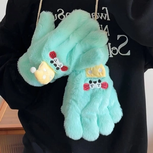 Détail de gants phoque vert menthe en peluche avec écusson dessin animé et texture douce
