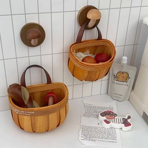 Detail of hand-woven wood storage baskets with leather handles and mushroom wall hooks