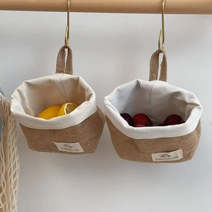 Detail of hanging jute storage baskets with canvas lining for kitchen wall organization
